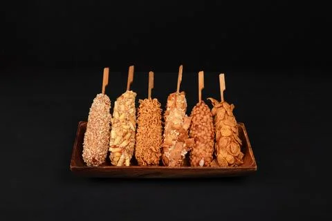 Assorted Korean Corn Dogs with Unique Toppings on Wooden Platter Stock Photos