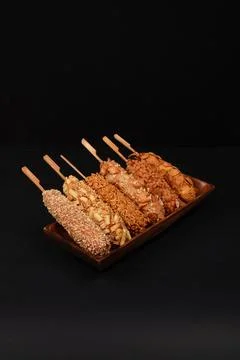 Assorted Korean Corn Dogs with Unique Toppings on Wooden Platter Stock Photos