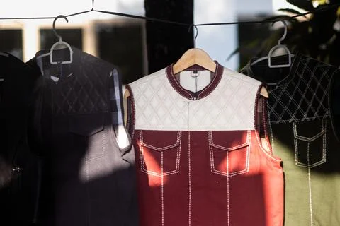 Assorted Leather Biker Vests Hanging on Wooden Clothes Hanger Stock Photos