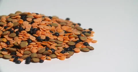 Assorted Lentils Pile Uncooked Spinning on White Stock Footage 64974464