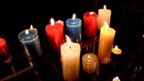 Assorted lit candles in a dark setting, creating a serene and warm atmosphere Stock Photos
