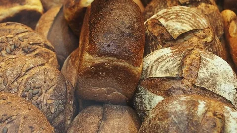 Assorted loaves of bread displayed in a bakery during the day Stock Footage 348259475