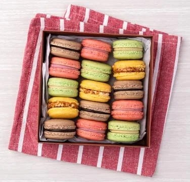 Assorted macarons in a gift box over wooden table Fotos Stock