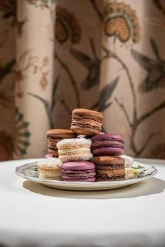 Assorted macarons stacked on decorative plate Stock Photos