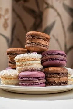 Assorted macarons stacked on decorative plate 스톡 사진