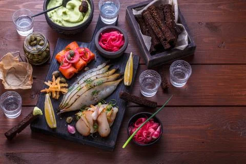 Assorted marinated fish on dark cutting board, copy space Stock Photos