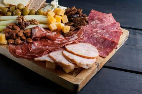 Assorted from meat and cheese on a chopping board. Smoked sausage, meat roll Stock Photos