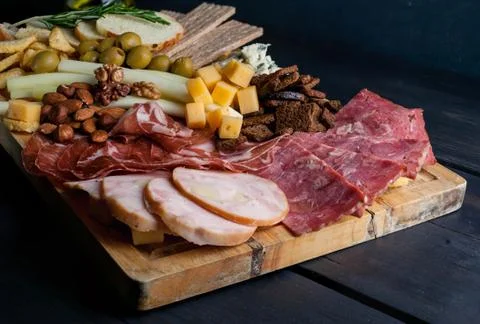 Assorted from meat and cheese on a chopping board. Smoked sausage, meat roll Stock Photos