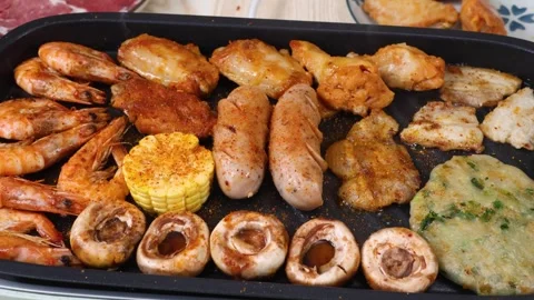 Assorted meat and seafood sizzling on a hot BBQ grill pan Stock Footage 339417390