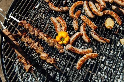 Assorted meat and vegetables grilling over fire Stock Photos