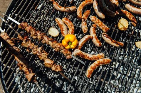 Assorted meat and vegetables grilling over fire Stock Photos