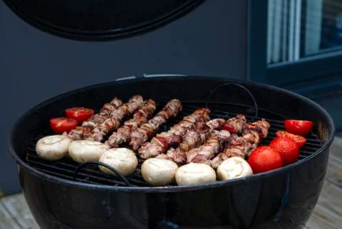 Assorted meat from chicken and various vegetables on barbecue grill Stock Photos