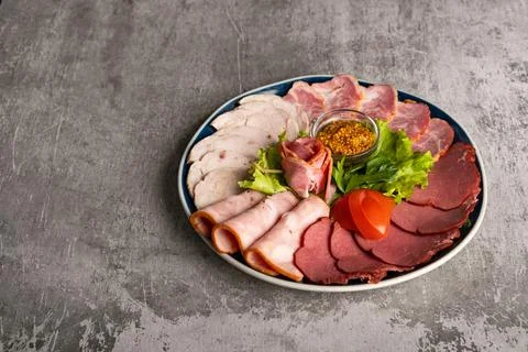 Assorted meat delicacies in a plate on the table Stock Photos
