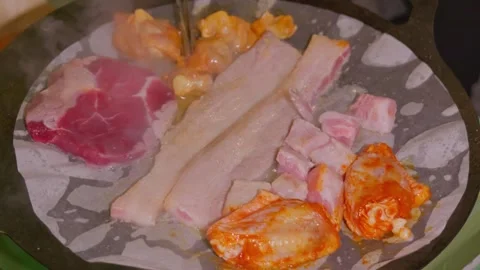 Assorted meats cook on round grill with parchment paper. Stock Footage 328617109