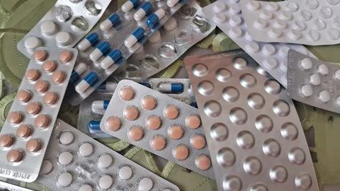 Assorted medicinal pills stored inside shiny silver colored plastic blister 스톡 사진