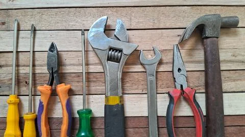 Assorted metal construction tools arranged neatly on a wooden background Stock Photos
