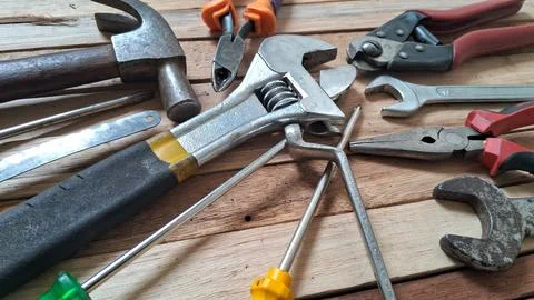 Assorted metal construction tools arranged neatly on a wooden background surface Stock Photos