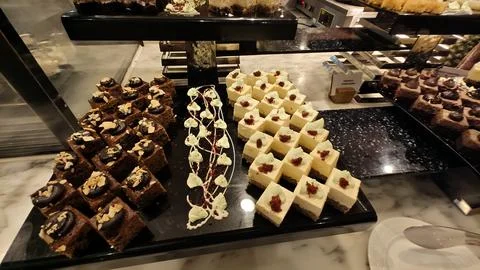 Assorted Mini Cakes &amp; Desserts Displayed on Luxury Hotel Buffet Dessert Counter 写真素材