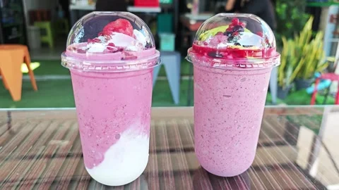 Assorted mixed berry smoothies with fruit toppings in plastic cups. Stock Footage 347514170