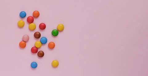 Assorted multicolored sweets dragee on a pink background Stock Photos