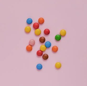 Assorted multicolored sweets dragee on a pink background Stock Photos