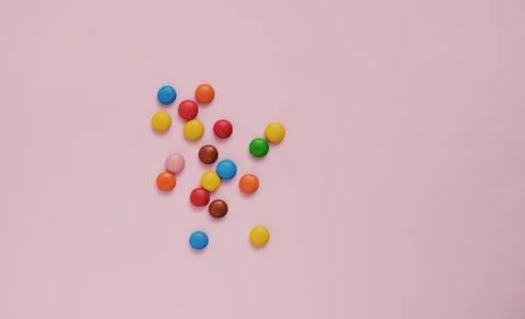 Assorted multicolored sweets dragee on a pink background Stock Photos