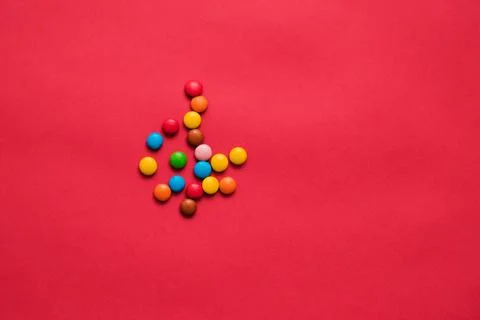 Assorted multicolored sweets dragee on a red background Stock Photos