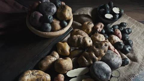Assorted native Peruvian potatoes and purple chips in a rustic setting. Stock Footage 339078417
