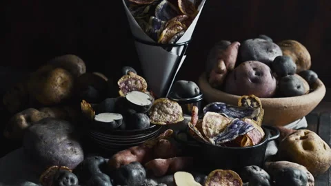 Assorted native Peruvian potatoes and purple chips in a rustic setting. 動画素材 339078467