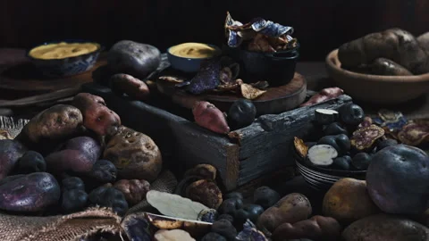 Assorted native Peruvian potatoes and purple chips in a rustic setting. Stock Footage 339078582