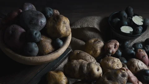 Assorted native Peruvian potatoes and purple chips in a rustic setting. Video stock 341440678