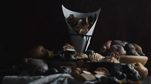 Assorted native Peruvian potatoes and purple chips in a rustic setting. 動画素材 344987080