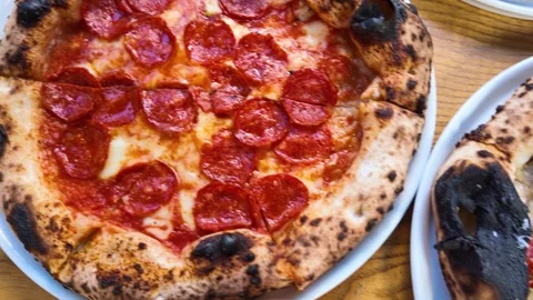 Assorted Neapolitan Pizzas on Wooden Table in Restaurant Setting Stock Footage 338319298