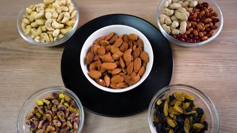 Assorted nuts and dried fruits on a wooden table Stock Footage 320726918