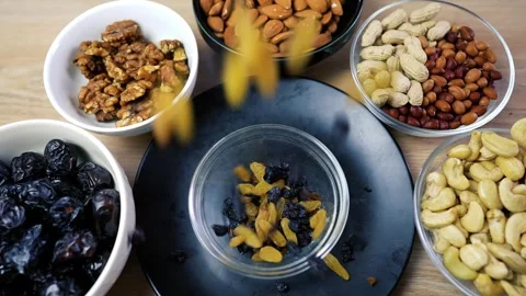Assorted nuts and dried fruits in bowls on a wooden table Stock Footage 320727440