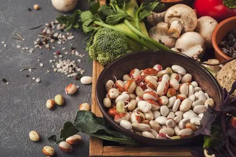 Assorted nuts in a black bowl on a rustic table Stock Photos