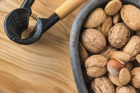 Assorted nuts on black ceramic bowl, top view Stock Photos