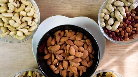 Assorted Nuts in Bowls on Wooden Table Stock Footage 320726987