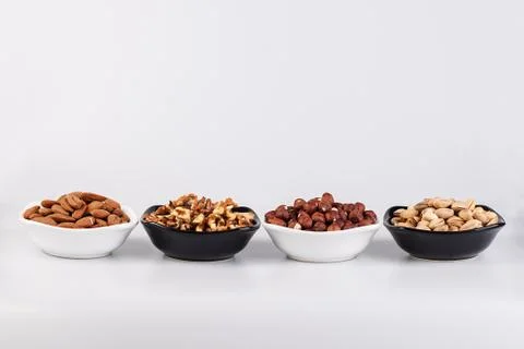 Assorted nuts in ceramic bowls Stock Photos