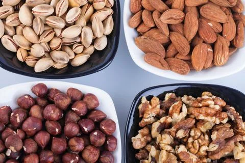 Assorted nuts in ceramic bowls Stock Photos
