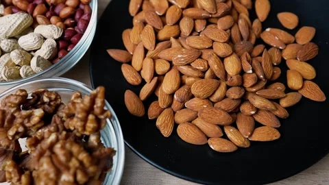 Assorted nuts including almonds, walnuts, and peanuts in bowls Stock Footage 320727108