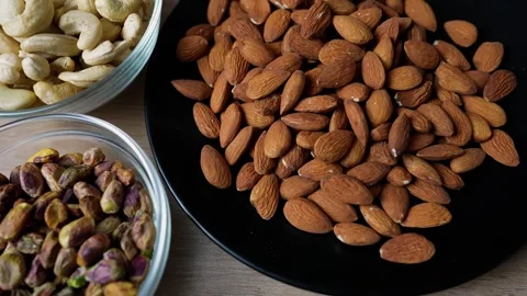 Assorted nuts including almonds, walnuts, and peanuts in bowls Stock Footage 320727120