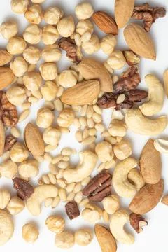 Assorted nuts mix on white background: hazelnuts, pine nuts, cashews, almonds Stock Photos