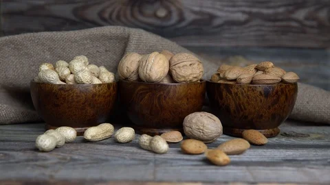 Assorted nuts-peanuts, almonds and walnuts in wooden cups Stock Footage 124528419