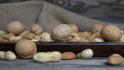 Assorted nuts-peanuts, almonds and walnuts in wooden plate Stock Footage 124555484
