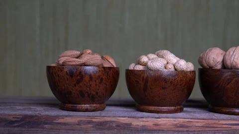 Assorted nuts-peanuts, almonds and walnuts in wooden cups Stock Footage 124555521