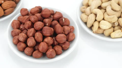 Assorted nuts pecans, almonds, cashews, hazelnuts on white background, rotation Video stock 153798421
