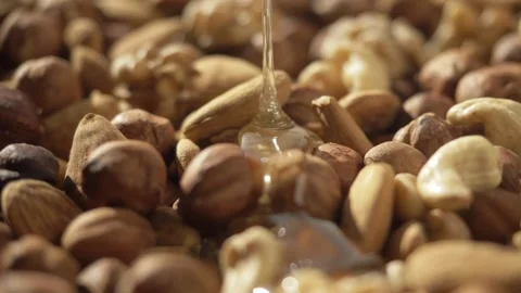 Assorted nuts, pine nuts, hazelnuts and cashews with honey. healthy food Stock Footage 143963925