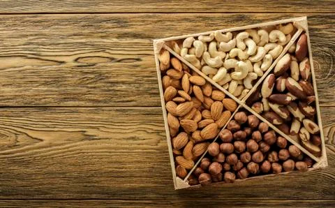 Assorted nuts. Set of nuts top view. Wooden table top. Texture background. Pl Stock Photos