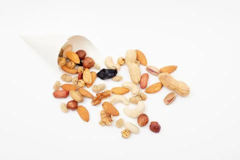 Assorted  Nuts  spill out of a paper cone on white background Stock Photos